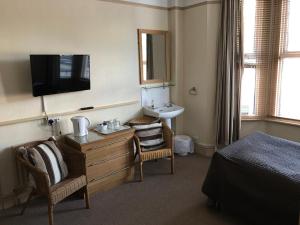 a hotel room with a bed and a sink and a bedroom at Holly Tree Guest House in Hereford