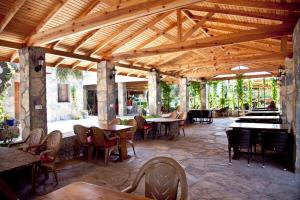 a restaurant with tables and chairs and a wooden ceiling at Şahin Motel & Restaurant in Yaliciftlik
