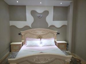 um quarto com uma cama grande e 2 mesas de cabeceira em appartement Annakhil em Marrakech