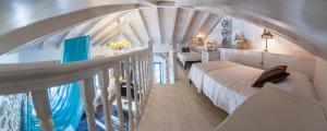 PortaDelMare deluxe suites في هيدرا: غرفة نوم بسرير في غرفة ذات سقف مقوس