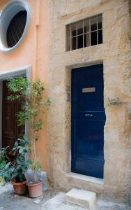 une porte bleue sur le côté du bâtiment dans l'établissement Valletta Period Townhouse, à La Valette