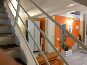 a staircase in a house with an orange wall at Sassi SediciDiciotto in Matera
