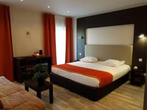 a hotel room with a bed and a couch at Hôtel Spa Les Alpes in Gréoux-les-Bains +69 photos