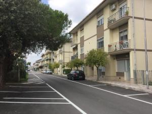 un'auto parcheggiata in una strada accanto a un edificio di Appartamenti Corallo ad Alba Adriatica