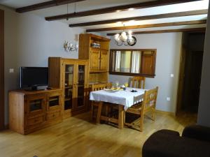 ein Esszimmer mit einem Tisch und einem Fernseher in der Unterkunft Duplex Usuaia con Jacuzzi in Lesaka