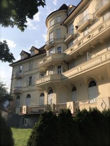 duży biały budynek z ludźmi na balkonach w obiekcie L'angolo di Sissi w mieście Gossensass-Colle Isarco