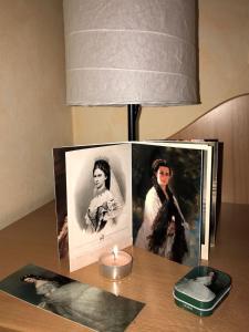 a candle on a table with a picture of a woman at L'angolo di Sissi in Colle Isarco