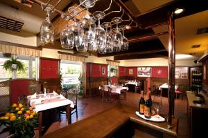 a restaurant with a dining room with tables and wine glasses at Penzion Budvarka in Hodonín