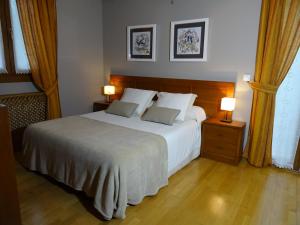 ein Schlafzimmer mit einem großen weißen Bett und zwei Lampen in der Unterkunft Duplex Usuaia con Jacuzzi in Lesaka