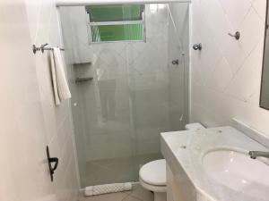 a bathroom with a shower and a toilet and a sink at Pousada Mar Do Leste in Florianópolis