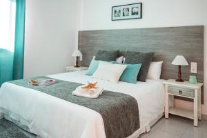 a bedroom with a large white bed with blue accents at Apartamento Almirante VV in Arrecife