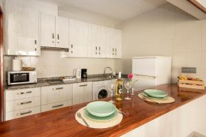 a kitchen with a wooden counter top with plates on it at Apartamento Almirante VV in Arrecife +8 photos