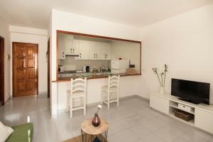 a living room with a kitchen with a counter and chairs at Apartamento Almirante VV in Arrecife