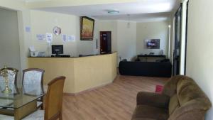 a living room with a couch and a counter at Hotel Vitalle in Juiz de Fora