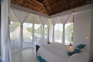 um quarto com 2 camas e uma grande janela em Cabañas Luxury em Bacalar