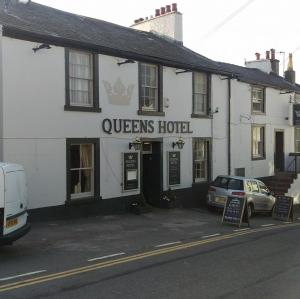 a queens hotel with a car parked in front of it at The Queens in St Bees