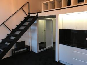 sala de estar con escalera y TV en Apartamentai Telegrafas en Kaunas