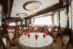 a dining room with a table with red roses on it at Hotel Silva Busteni in Buşteni