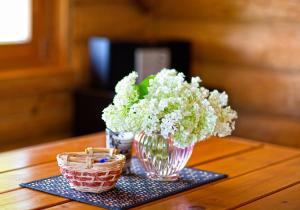 un jarrón de flores sentado en una mesa con dos cestas en Ezerkalni, en Raiskums