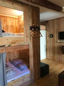 Ce lit superposé se trouve dans un dortoir doté de murs en bois. dans l'établissement Le Passage, à Ax-les-Thermes
