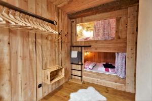 two bunk beds in a room with wooden walls at Le Passage in Ax-les-Thermes