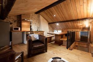 a kitchen with a leather chair in a room with wooden ceilings at Le Passage in Ax-les-Thermes