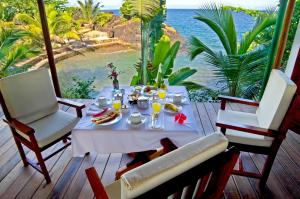 a table with food and a view of the ocean at Samaria Lodge in Sainte Marie