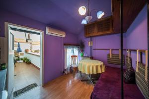 a room with purple walls and a table with a yellow table cloth at Sunny Apartment Sofia in Sofia