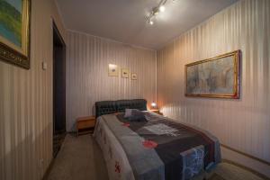 ソフィアにあるSunny Apartment Sofiaのベッドルーム1室(ベッド1台付)が備わります。壁に絵が飾られています。