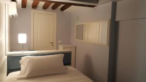 Schlafzimmer mit einem Bett, einem Fenster und einem Spiegel in der Unterkunft Maison d'Elite Guest House in Venedig