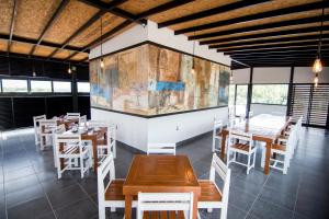 Maria Ines Hotel Suite في مدينة أواكساكا: مطعم بطاولات خشبية وكراسي بيضاء