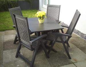 a black table and chairs with a vase of yellow flowers at Ferienwohnung Nähe Altstadt in Sassnitz