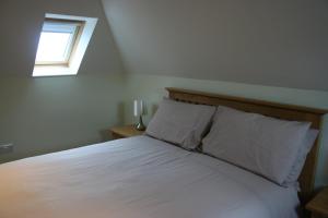 Schlafzimmer mit einem weißen Bett und einem Fenster in der Unterkunft Highlands Apartment 4 in Shanklin