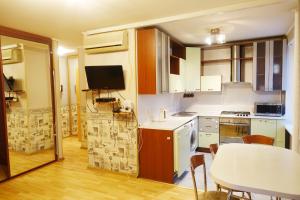 モスクワにあるАпартаменты Азовскаяのキッチン(白いキャビネット、テーブル付)、ダイニングルーム