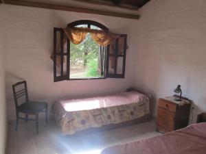 - une chambre avec un lit, une fenêtre et une chaise dans l'établissement Luna Azul, à Nono