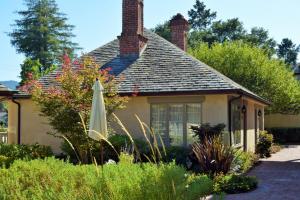 ein Haus mit Sonnenschirm in einem Garten in der Unterkunft Vineyard Country Inn in St. Helena