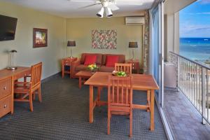 Pacific Monarch Hotel في هونولولو: غرفة معيشة مع طاولة وأريكة