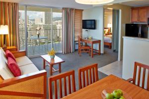 a living room with a couch and a dining room at Pacific Monarch Hotel in Honolulu