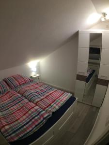 een kleine slaapkamer met een bed en een spiegel bij Ferienwohnung MILA Braunlage in Braunlage