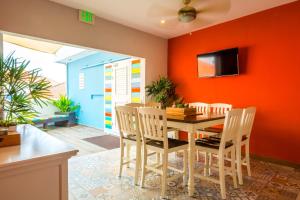 Bed & Bike Curacao في فيليمستاد: غرفة طعام بجدران برتقالية وطاولة وكراسي