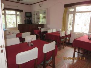 a dining room with red tables and white chairs at New United Hotel in Pokhara