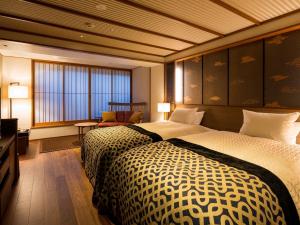 a hotel room with two beds and a television at Kasuien Minami in Matsue