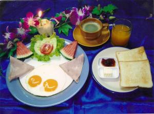 dos platos de comida con huevos y pan y una taza de café en Beachfront Hotel Cha Am, en Cha Am
