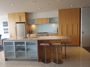 een keuken met een eiland met een aanrecht en krukken bij Waimahana Apartment 4 in Taupo
