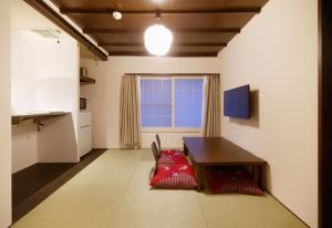 uma sala de estar com uma mesa e uma janela em Miyabi Cosy House em Quioto