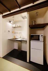 uma pequena cozinha com um lavatório e um micro-ondas em Miyabi Cosy House em Quioto
