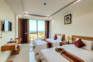 a hotel room with two beds and a balcony at Amanda Hotel in Dong Hoi