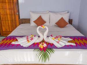 two swans made out of towels on a bed at Bintang Hostel and Homestay in Nusa Penida
