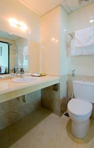 a bathroom with a toilet and a sink and a mirror at Amanda Hotel in Dong Hoi