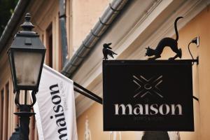 a black and white cat standing on top of a sign at Maison Bistro & Hotel in Budapest